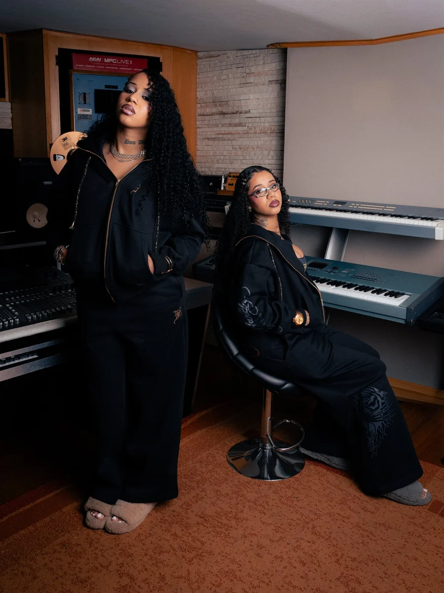 Tasha e Tracie em estúdio de música com conjuntos de moletom preto da Ed Hardy