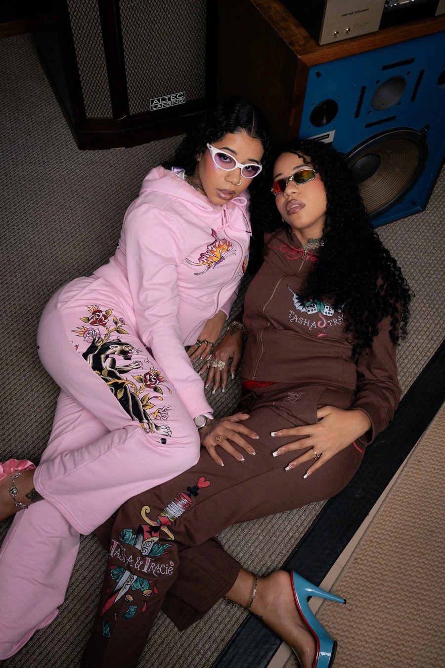 Tasha e Tracie com conjuntos de moletom rosa e marrom da coleção Ed Hardy