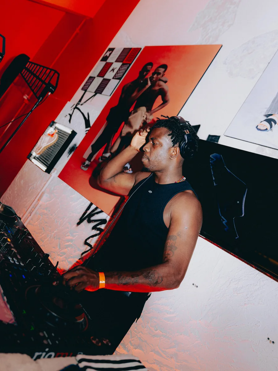DJ toca na festa de inauguração da loja da Kenner, com o K da marca na parede