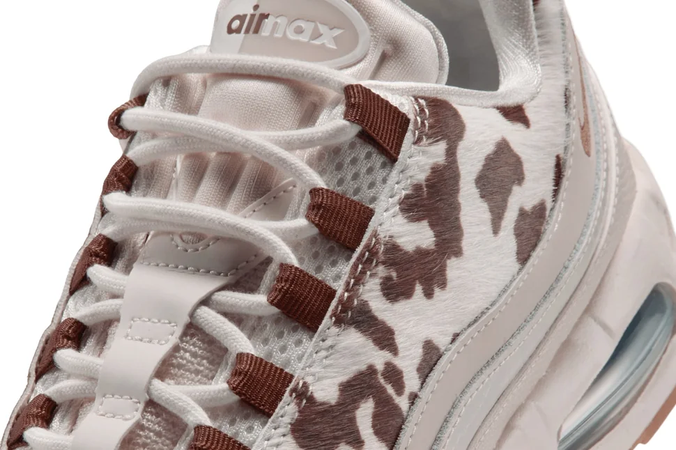 Detalhe dos passadores de cadarço em fita marrom do Air Max 95 Cow Print