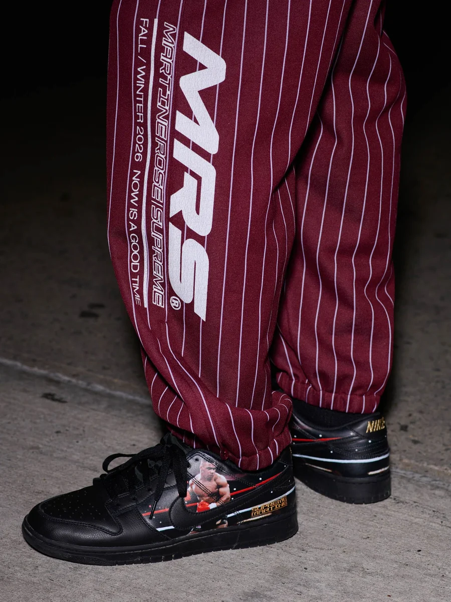 Nike Dunk Low preto com foto de Mike Tyson no pé de modelo com calça listrada