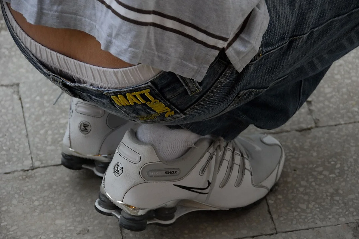 Pessoa usando Nike Shox branco com molas no calcanhar na rua