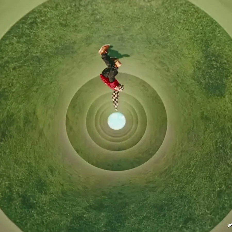 Figura de cabeça para baixo no túnel circular de grama no clipe de Shroom Clouds, de A$AP Rocky