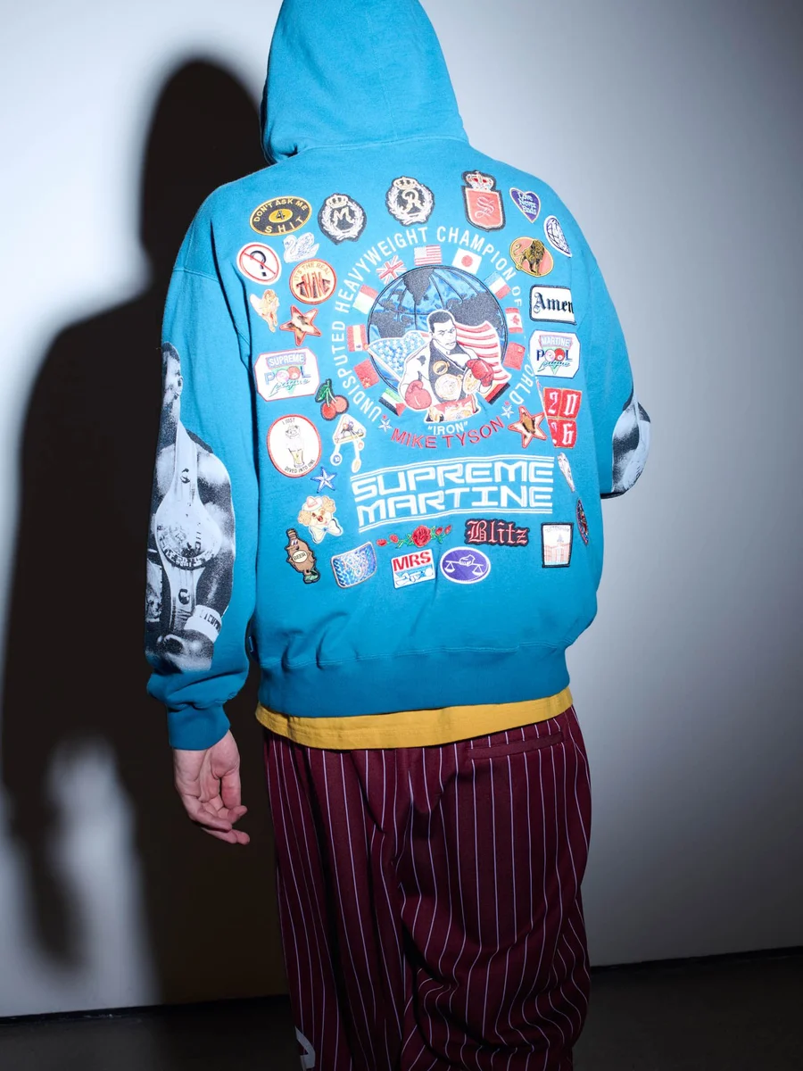 Costas de moletom azul com patches de boxe e fotos de Mike Tyson nas mangas