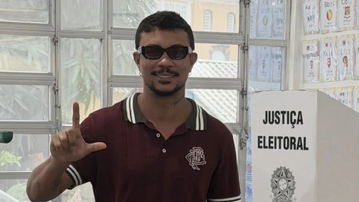 Xamã de óculos escuros ao lado da cabine de votação da Justiça Eleitoral no segundo turno de 2026
